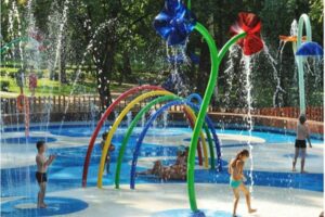 [Photo of kids playing at a splashpad]